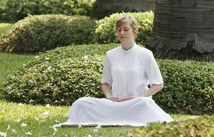 woman doing meditation in the grass